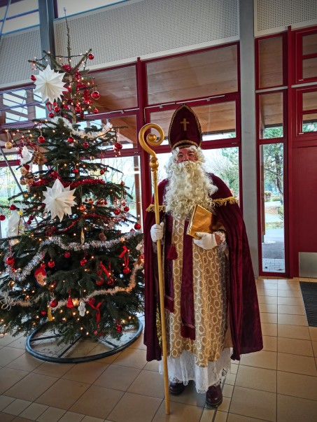 Nikolaus steht vor Weihnachtsbaum